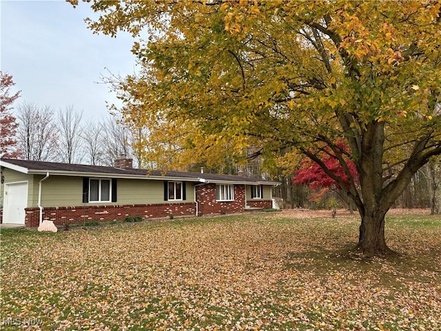 single story home featuring a garage and a front lawn