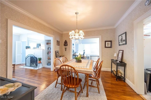 dining room featuring wood-type flooring, a chandelier, and ornamental molding