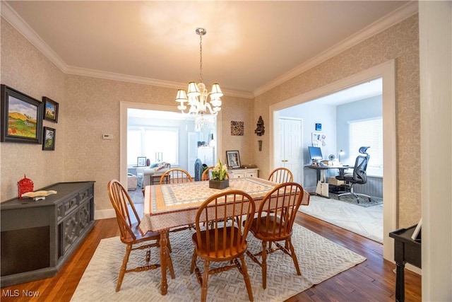 dining room with a notable chandelier, dark hardwood / wood-style flooring, and ornamental molding