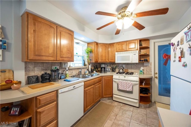 kitchen with white appliances, ceiling fan, backsplash, and sink