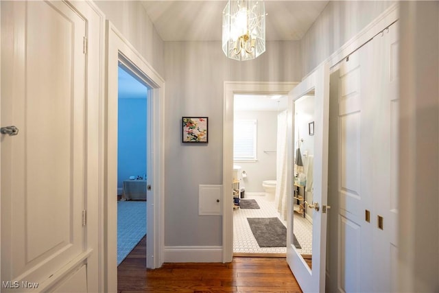 hall featuring dark hardwood / wood-style flooring and a notable chandelier