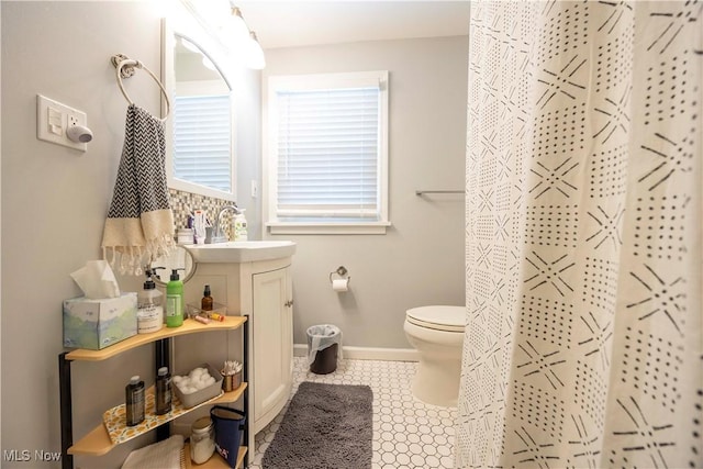 bathroom with walk in shower, tile patterned flooring, vanity, and toilet