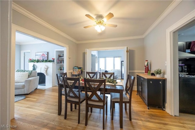 dining room with ceiling fan, light wood-type flooring, and crown molding