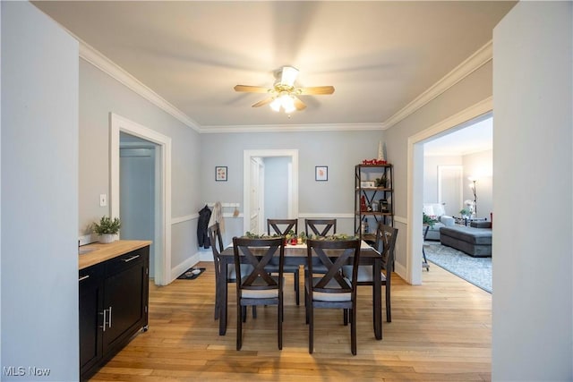 dining area with ceiling fan, light hardwood / wood-style floors, and ornamental molding