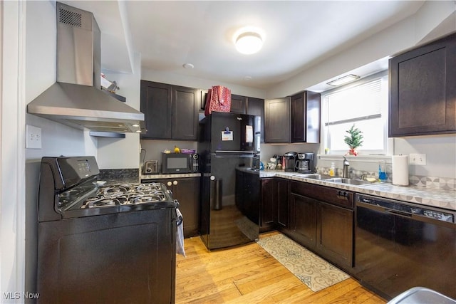 kitchen featuring sink, light hardwood / wood-style flooring, dark brown cabinetry, range hood, and black appliances