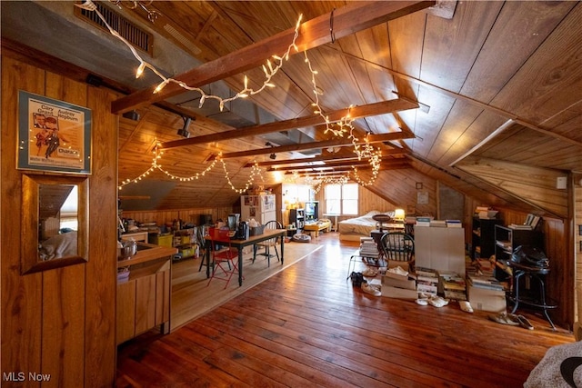 interior space with wood ceiling, hardwood / wood-style floors, lofted ceiling with beams, and wood walls