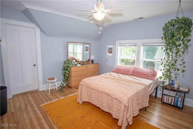 bedroom with ceiling fan, light hardwood / wood-style flooring, and lofted ceiling