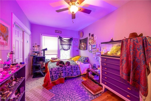 bedroom featuring ceiling fan, a closet, and hardwood / wood-style flooring