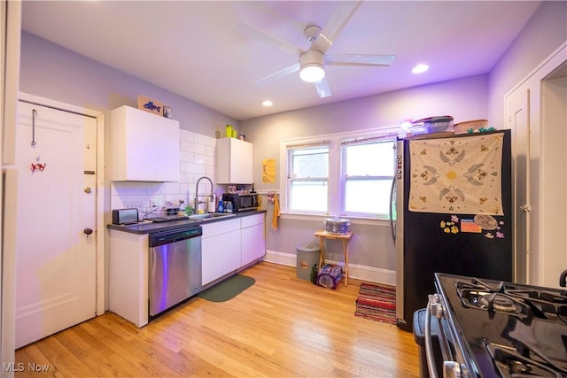 kitchen featuring appliances with stainless steel finishes, light wood-type flooring, decorative backsplash, sink, and white cabinetry