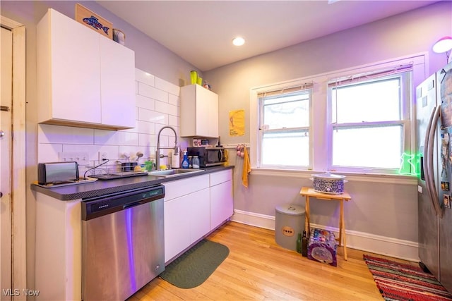 kitchen featuring sink, stainless steel appliances, white cabinetry, and light hardwood / wood-style floors