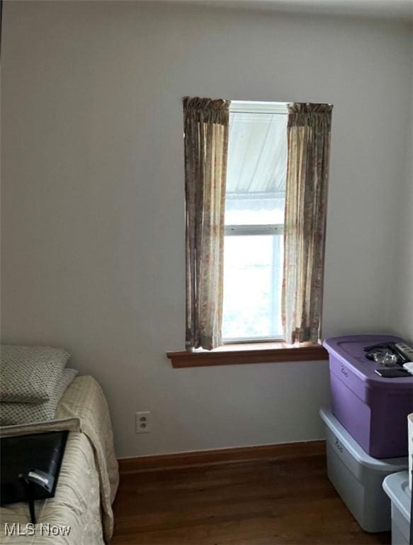 bedroom with dark hardwood / wood-style floors