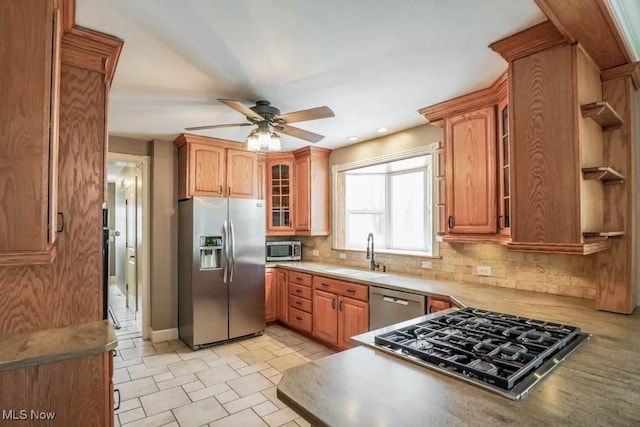 kitchen with stainless steel appliances, ceiling fan, tasteful backsplash, and sink