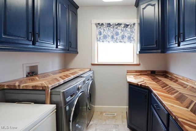 clothes washing area featuring cabinets and independent washer and dryer