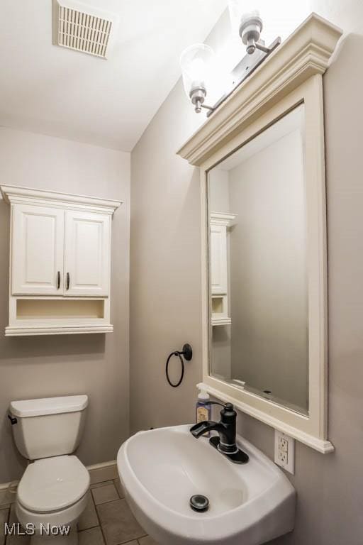 bathroom with sink, toilet, and tile patterned floors