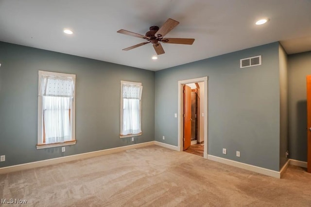 empty room with ceiling fan and light carpet