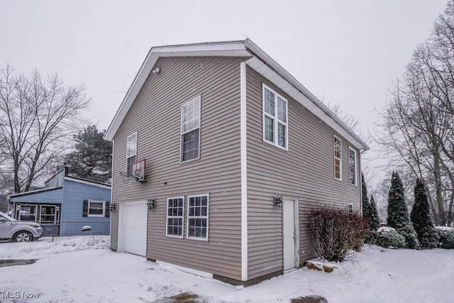 snow covered property featuring a garage