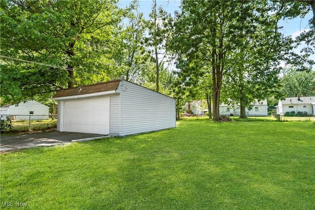 view of yard with a garage and an outbuilding