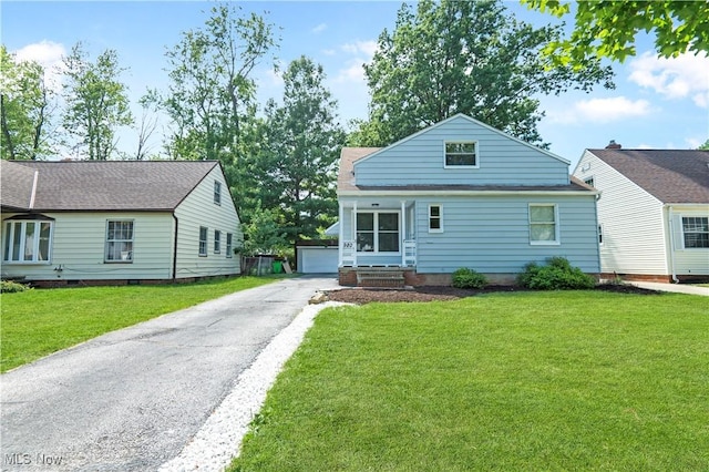 view of front of house with a front lawn, a garage, and an outdoor structure