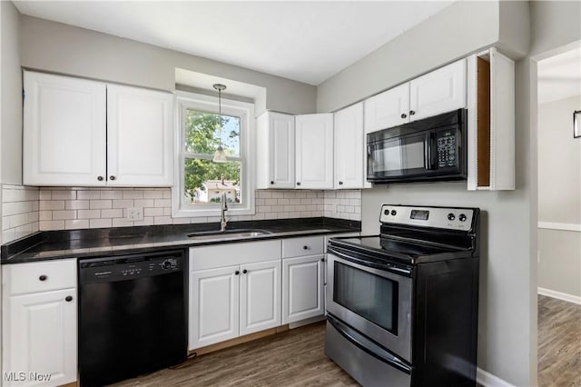 kitchen with sink, dark hardwood / wood-style flooring, white cabinetry, and black appliances