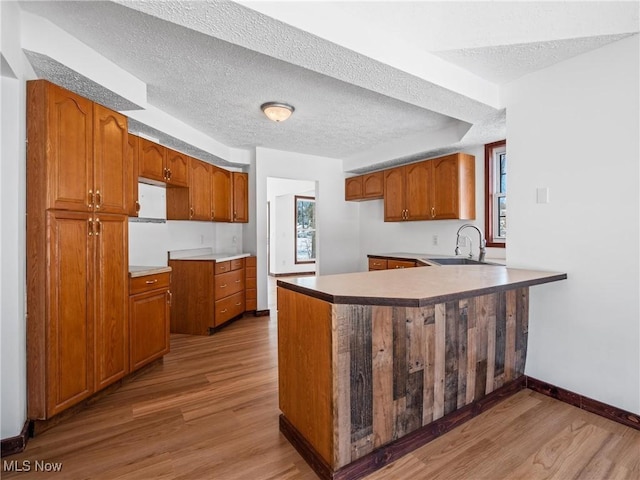 kitchen featuring kitchen peninsula, a textured ceiling, and sink