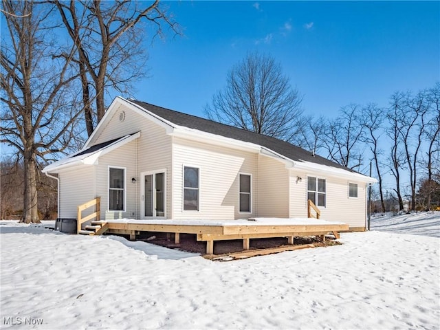 snow covered rear of property featuring a deck