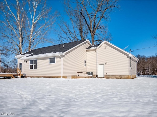 snow covered property with central air condition unit