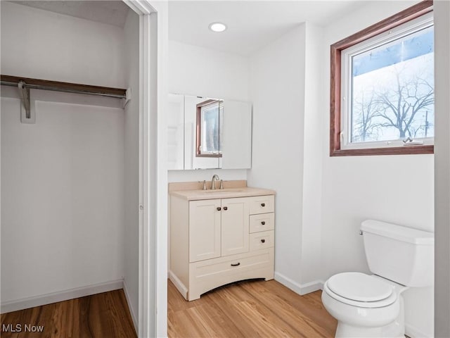 bathroom with toilet, vanity, and hardwood / wood-style flooring