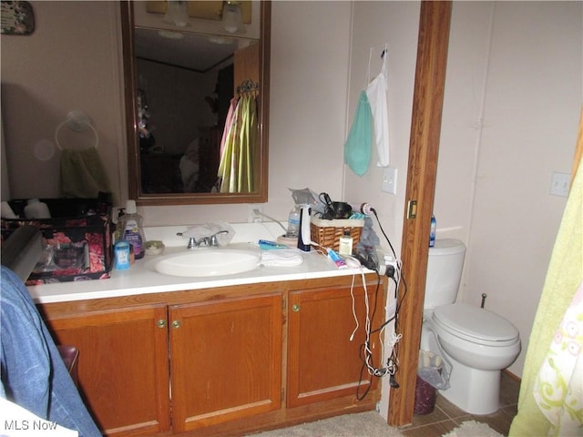 bathroom with tile patterned flooring, vanity, and toilet