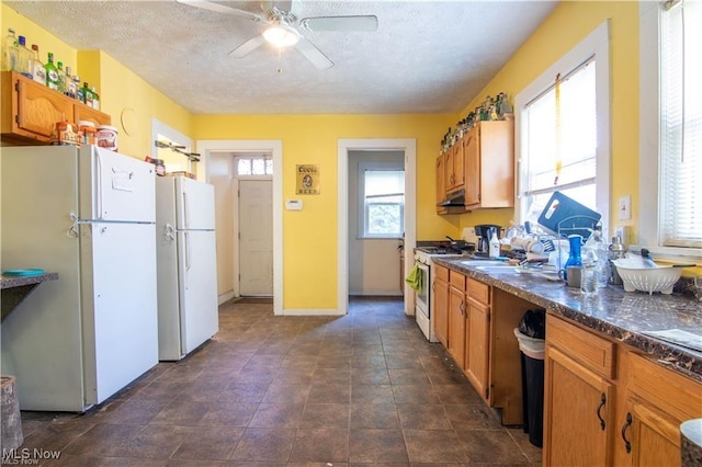 kitchen featuring white appliances, a textured ceiling, ceiling fan, and plenty of natural light