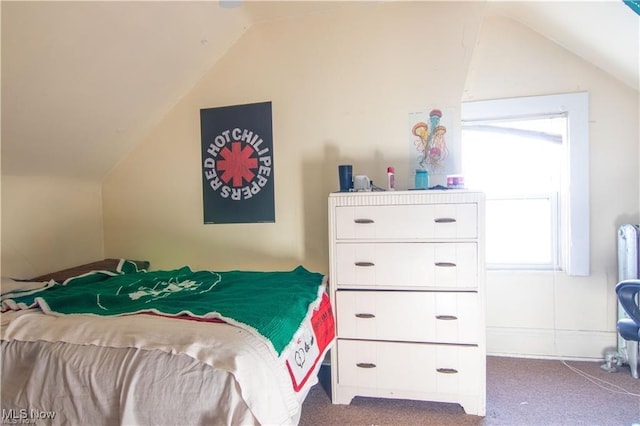 bedroom featuring lofted ceiling and dark colored carpet