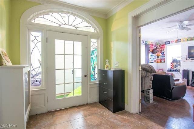 doorway to outside featuring ceiling fan, ornamental molding, and a healthy amount of sunlight