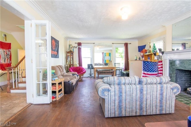 living room featuring a textured ceiling, crown molding, dark hardwood / wood-style flooring, and a high end fireplace