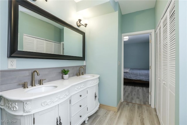 bathroom featuring backsplash, vanity, and wood-type flooring