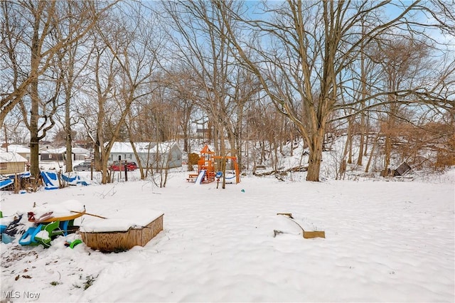 yard layered in snow with a playground