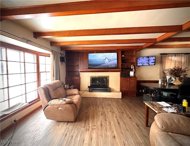 living room featuring light wood-type flooring and beamed ceiling