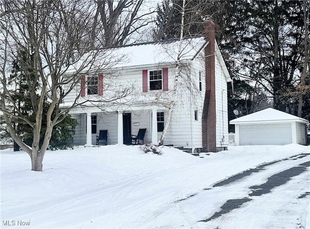 colonial-style house with a garage and an outbuilding