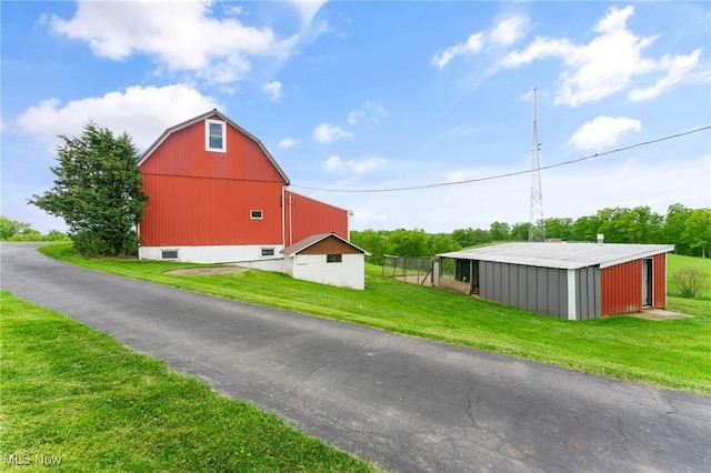 view of side of property featuring a yard and an outdoor structure