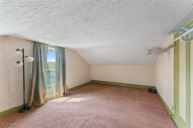 additional living space with a textured ceiling, a baseboard radiator, carpet, and vaulted ceiling