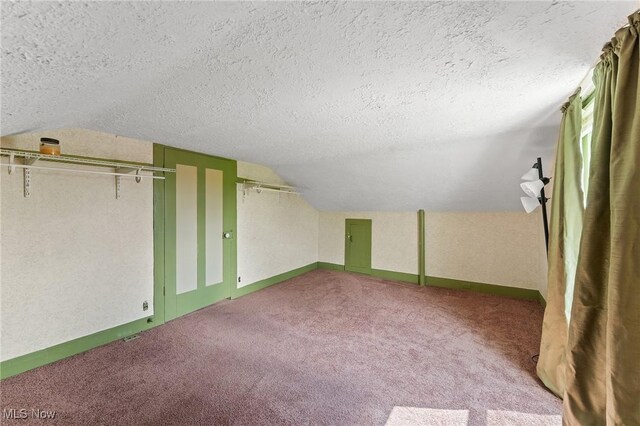 additional living space featuring lofted ceiling, a textured ceiling, and light colored carpet