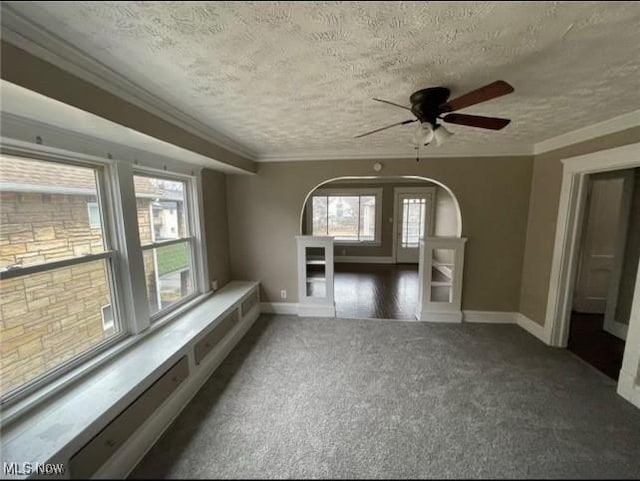 carpeted spare room with ornamental molding, a textured ceiling, and ceiling fan