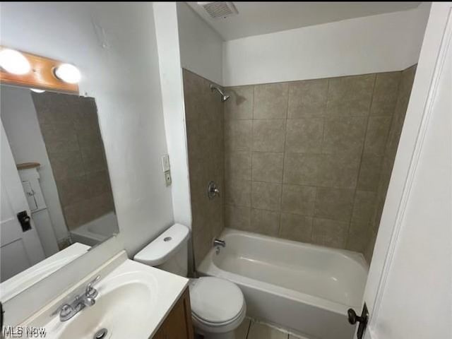 full bathroom featuring toilet, vanity, tile patterned floors, and tiled shower / bath combo