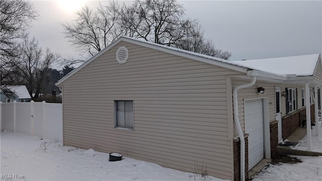 snow covered property featuring a garage