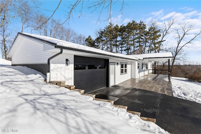 view of snowy exterior with a garage