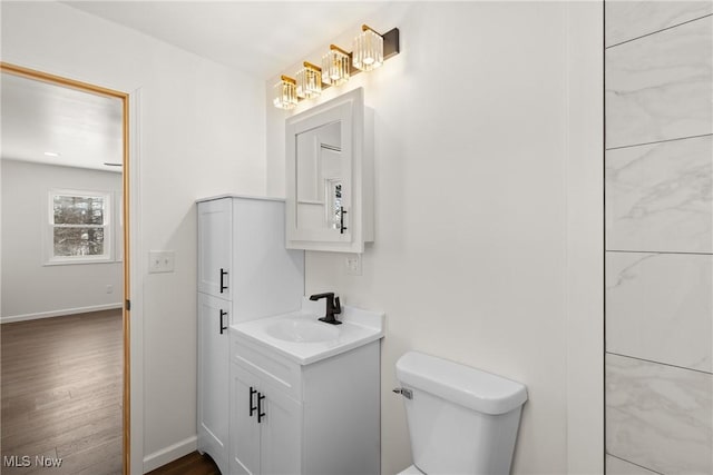 bathroom featuring toilet, hardwood / wood-style flooring, and vanity