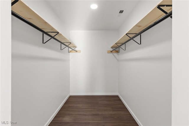 spacious closet featuring dark hardwood / wood-style floors