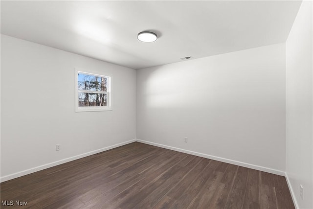 spare room with dark hardwood / wood-style floors