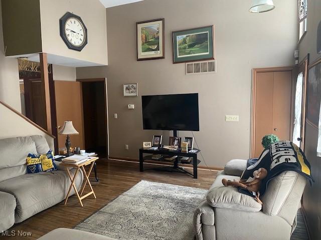 living room with a high ceiling and dark hardwood / wood-style floors