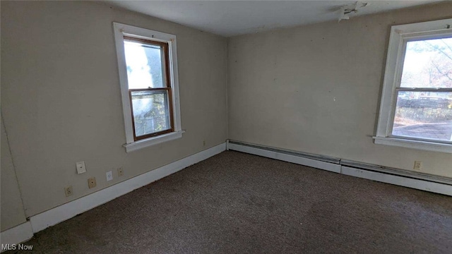 spare room featuring a baseboard radiator and dark colored carpet