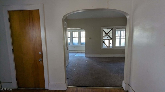 hallway with baseboard heating and dark wood-type flooring