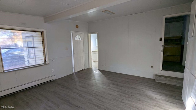 empty room featuring baseboard heating and dark wood-type flooring